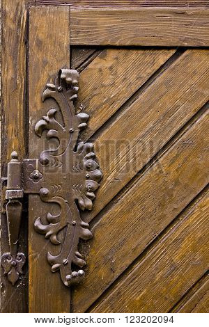 Vintage iron door hinges. Wrought iron hinges on the wooden door.