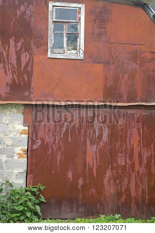 Rusty wall texture background of a two store house with window brick and bush. Vivid old copper metal background texture