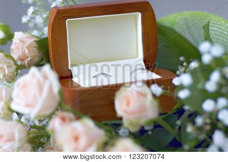 Wedding rings in the jewel box decorated with roses