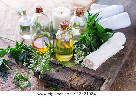 Organic essential aroma oil with herbs on aged wooden background. Homeopaty. Selective focus.