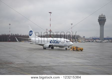 ST. PETERSBURG, RUSSIA - DECEMBER 12, 2015: Towing of aircraft Boeing 737-500 (VQ-BJQ) UTair aviation on the airfield. Pulkovo Airport