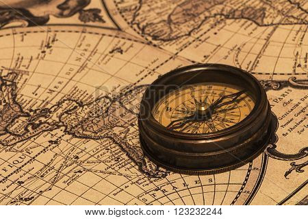 The old brown metal compass on a world map background.
** Note: Shallow depth of field