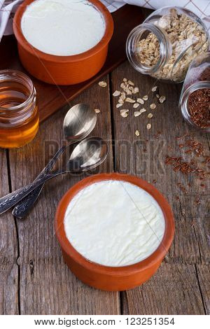 Home made greek yogurt in claypot as traditional with honey, oatmeal and flax seeds