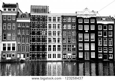 AMSTERDAM; THE NETHERLANDS - AUGUST 16; 2015: Beautiful views of the ancient buildings at the waterside, Damrak canal in Amsterdam. Amsterdam is capital of the Netherlands on August 16; 2015.