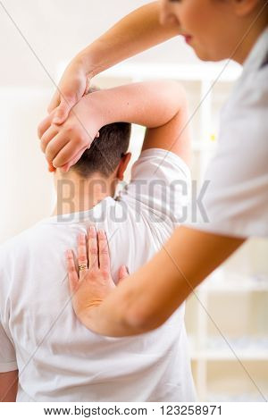 Chiropractor doing adjustment on male patient at doctor's office