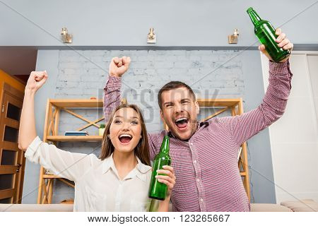 Happy Lovers Watching Football With Beer And Raised Hands