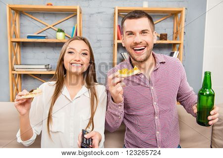 Portrait Of Happy Man And Woman Watching Comedy And Eating Pizza