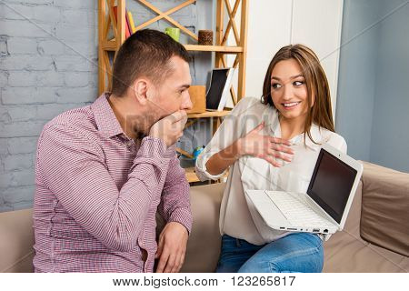Shocked Husband Lookind At High Price. Wife Showing Laptop