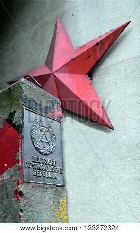 BERLIN, UK - AUGUST 9, 2012: German Democratic Republic sign and red star near Checkpoint Charlie between east and west sectors during the Cold War