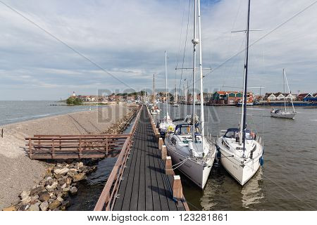 URK, THE NETHERLANDS - AUG 29: Wooden pier and moored sailing ships with tourists on August 29, 2015 in the harbor of Urk, the Netherlands