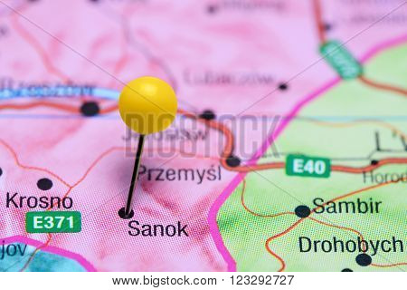 Photo of pinned Sanok on a map of Poland. May be used as illustration for traveling theme.