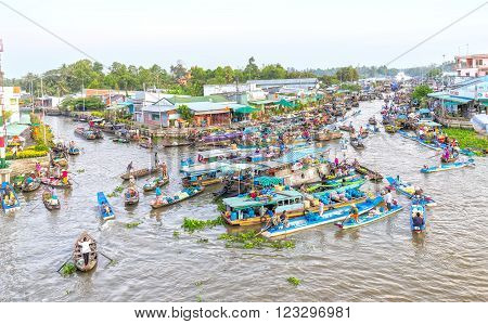 Soc Trang, Vietnam - February 3rd, 2016: Agricultural morning floating market bustling with agricultural boatload focus rotation trafficking intersection into river in sunny morning as wetland culture in Soc Trang, Vietnam