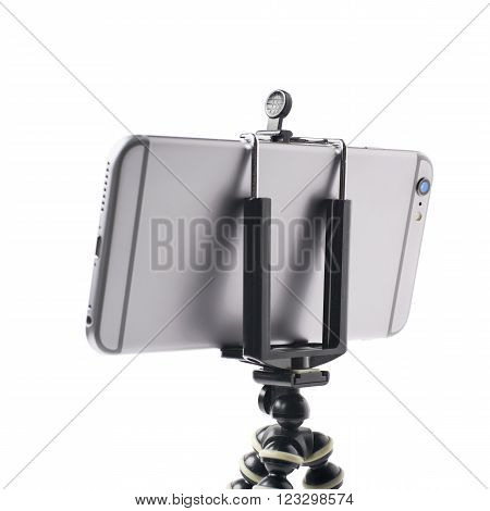 Smartphone set up on a tripod isolated over the white background