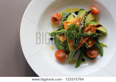 Healthy gourmet Halumi Salad with asparagus, cherry tomatoes, and avocado