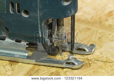 Electricsaw close-up in a working position on the background of OSB