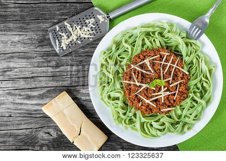Bolognese ragout with green pasta tagliatelle top view