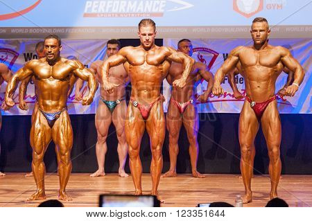 MAASTRICHT THE NETHERLANDS - OCTOBER 25 2015: Male bodybuilders flex their muscles and shows their best front pose on stage at the World Grandprix Bodybuilding and Fitness of the WBBF-WFF on October 25 2015 at the MECC Theatre in Maastricht