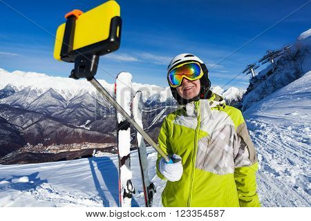 Young woman with selfie stick taking photo on ski resort