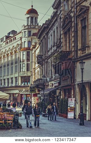 Bucharest, Romania - October 6, 2013: Tourists wander the cobblestone streets of the historic center Lipscani, the Bucharest's liveliest entertainment district.