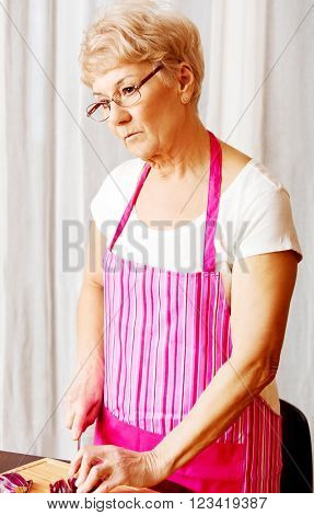 Woman cut red onion on cutting board