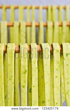 Homemade tagliatelle green hanging to dry. Selective focus.