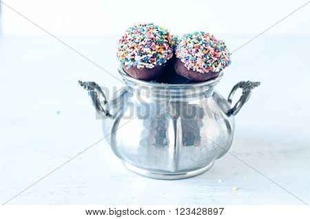 Small cupcake with chocolate in the shape of Chupa Chups decorated with sugar