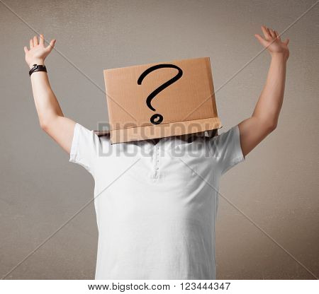 Young man standing and gesturing with a cardboard box on his head with question mark