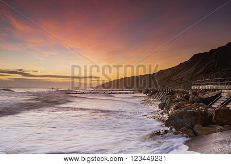 Looking along the coast at sunrise on Mundesley beach.