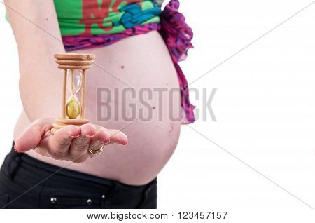 Conceptual Image Of A Young Pregnant Woman Holding An Hourglass Next To Her Belly