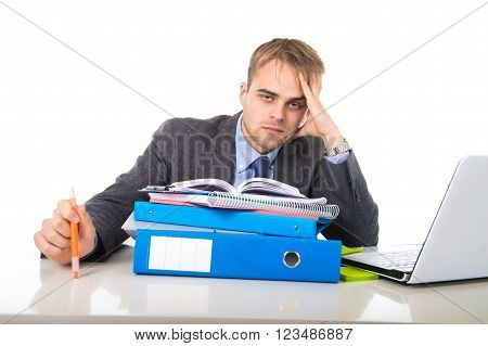 young businessman overworked and overwhelmed suffering work stress at office computer desk looking tired sad and frustrated