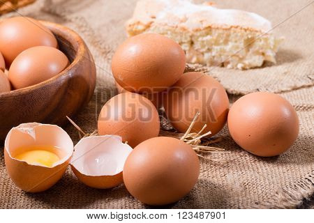 Eggs and pie on a sacking. One egg is broken rural style a close up
