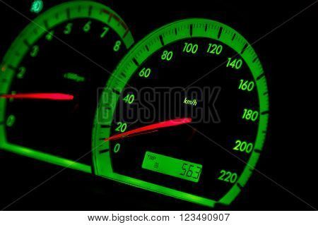 motometer and speedometer green highlighted in a car at night