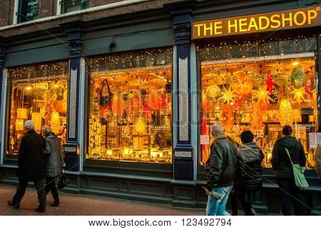 AMSTERDAM HOLLAND - DECEMBER 30: A shop window on the evening streets of Amsterdam. In the evening bright and varied lighting of streets of the city attracts many tourists on 30 december 2012