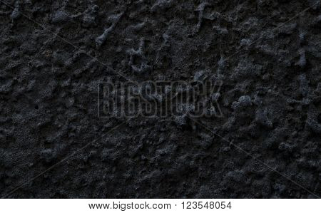 Rough wall covered with dark gray stucco