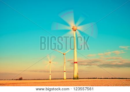 Modern Wind Turbines Producing Energy In Sunny Spring Morning. Vintage Style Toned Effect