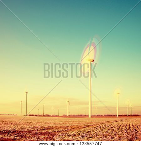 Modern Wind Turbines Producing Energy in suny spring morning. Vintage Style Toned effect