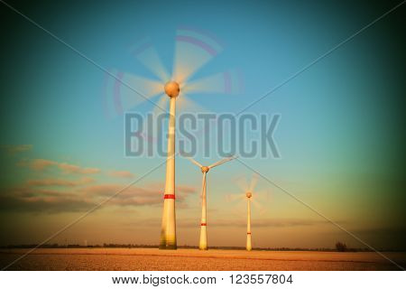 Wind Turbines Producing Electric Energy within sunny spring morning. Vintage Style Toned effect