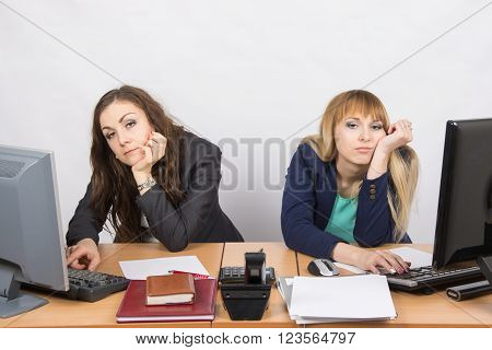 Two Young Employee Of The Office Behind A Desk Looking Sadly Into The Frame