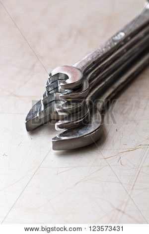 Pyramid of 5 silver wrenches on the scratched background