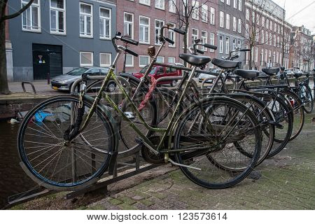 AMSTERDAM HOLLAND - DECEMBER 30: Old bikes on the canal in Amsterdam. Bike is one of the most popular means of transportation in the city on 30 december 2012