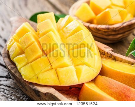 Mango fruit and mango cubes on the wooden table.