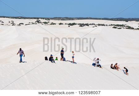 LANCELIN,WA,AUSTRALIA-SEPTEMBER 28,2015: People sand surfing and sledding the white sand dunes in Lancelin, Western Australia.