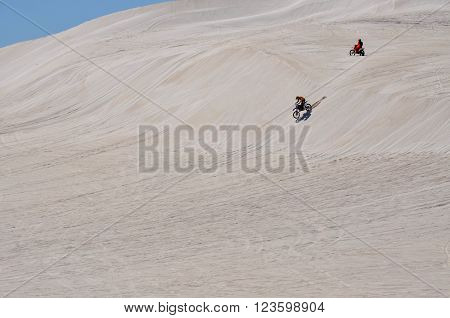 LANCELIN,WA,AUSTRALIA-SEPTEMBER 28,2015: Motorbike riders racing the hills of the white sand dunes in Lancelin, Western Australia.