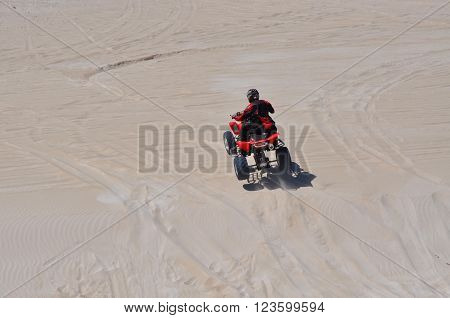 LANCELIN,WA,AUSTRALIA-SEPTEMBER 28,2015: Quad bike and rider at the white sand dunes tourist attraction in Lancelin, Western Australia.