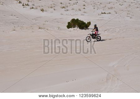 LANCELIN,WA,AUSTRALIA-SEPTEMBER 28,2015: Motorbike rider at the white sand dunes tourist attraction in Lancelin, Western Australia.