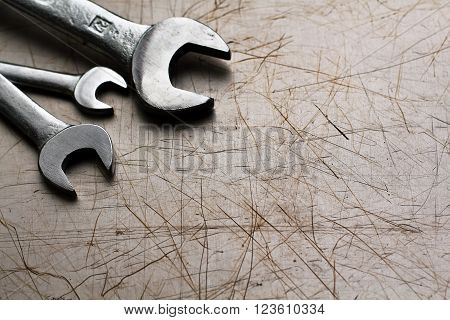 three steel wrenches on a metal background