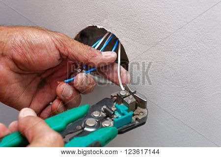 Mans hands holding toool installing wires, copyspace