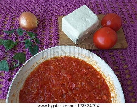 Tofu tomato onion with melissa cooking healthy food for a vegetarian diet.