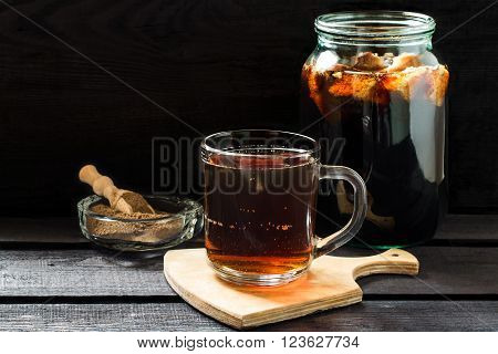 Traditional Russian drink kvass made from bread rye malt sugar and water. Kvass in the jar rye malt in a bowl with scoop on a dark wooden background. Selective focus