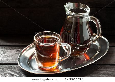 Traditional Russian drink kvass made from bread rye malt sugar and water. Kvass in the jug and mug on a dark wooden background